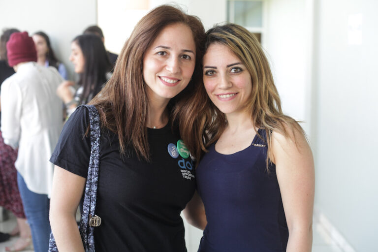 Two young women smile at camera